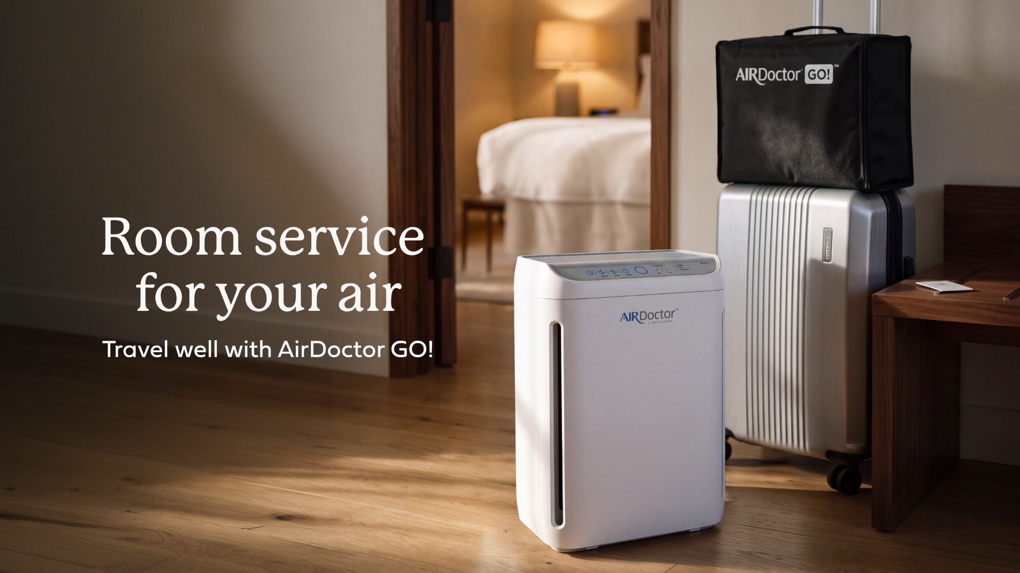 AirDoctor GO portable air purifier beside luggage in a hotel room, with the text Room service for your air